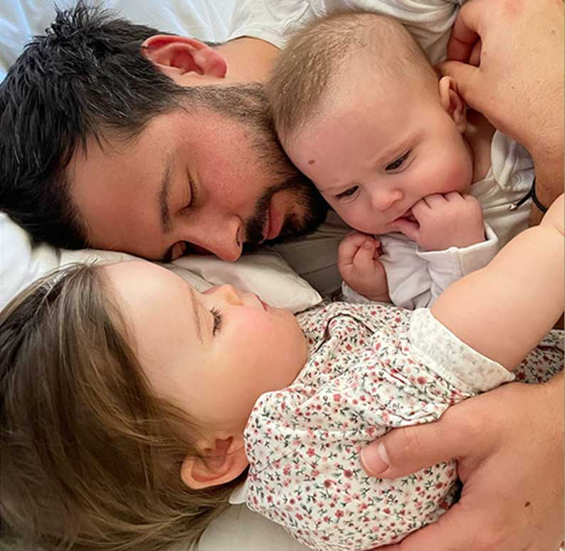 Parent lying beside two young children