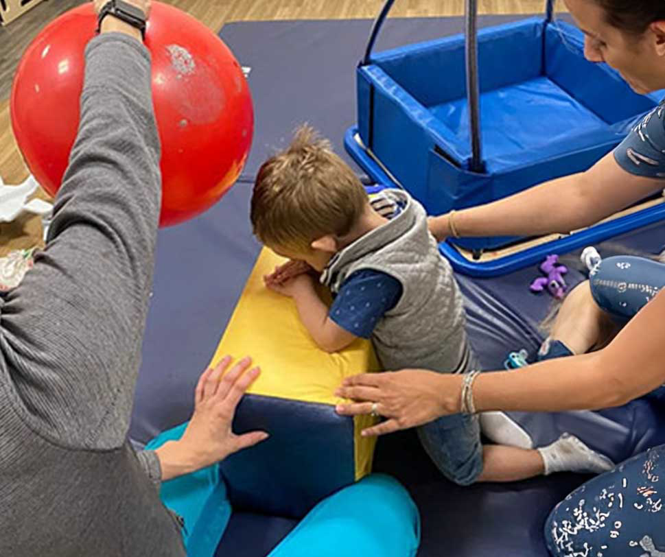 Child participating in a therapy session with caregivers